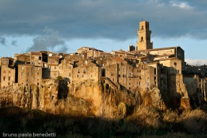 pitigliano sunset view of ancient houses and chirch by red light of sunset