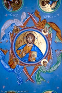 icon of Jesus Christ on a vault in Georgian orthodox church in blue color dominant with inscription in Georgian alphabet